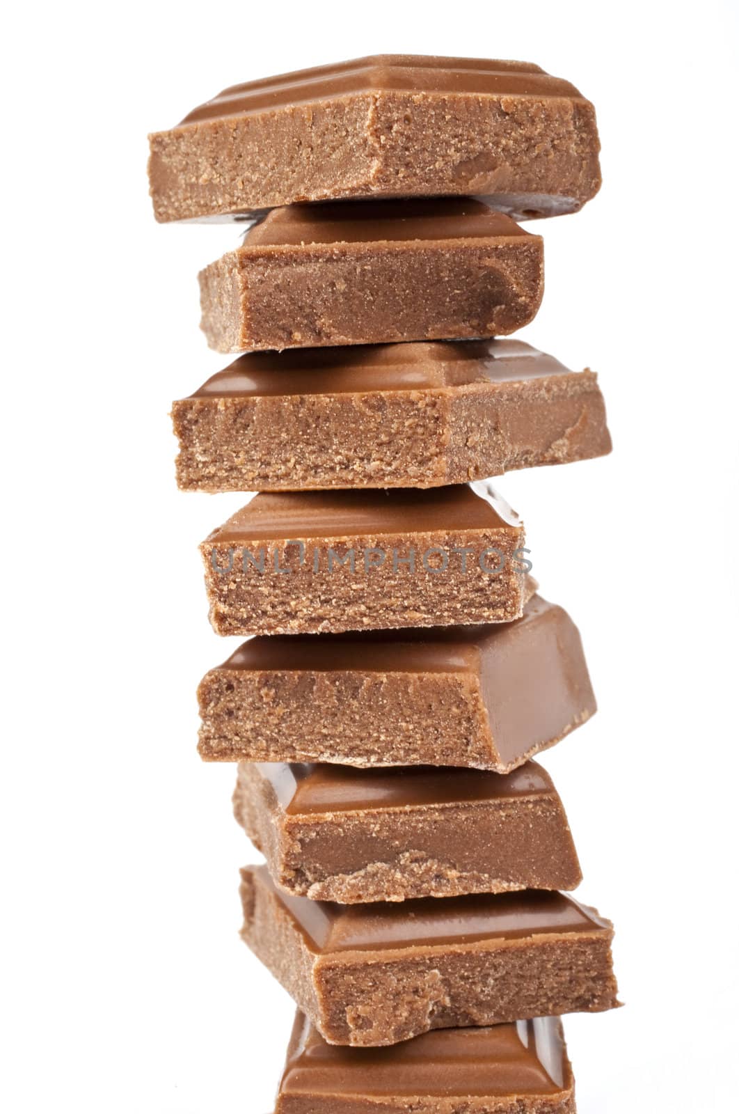 Chunks of Chocolate piled up in front of a white background.