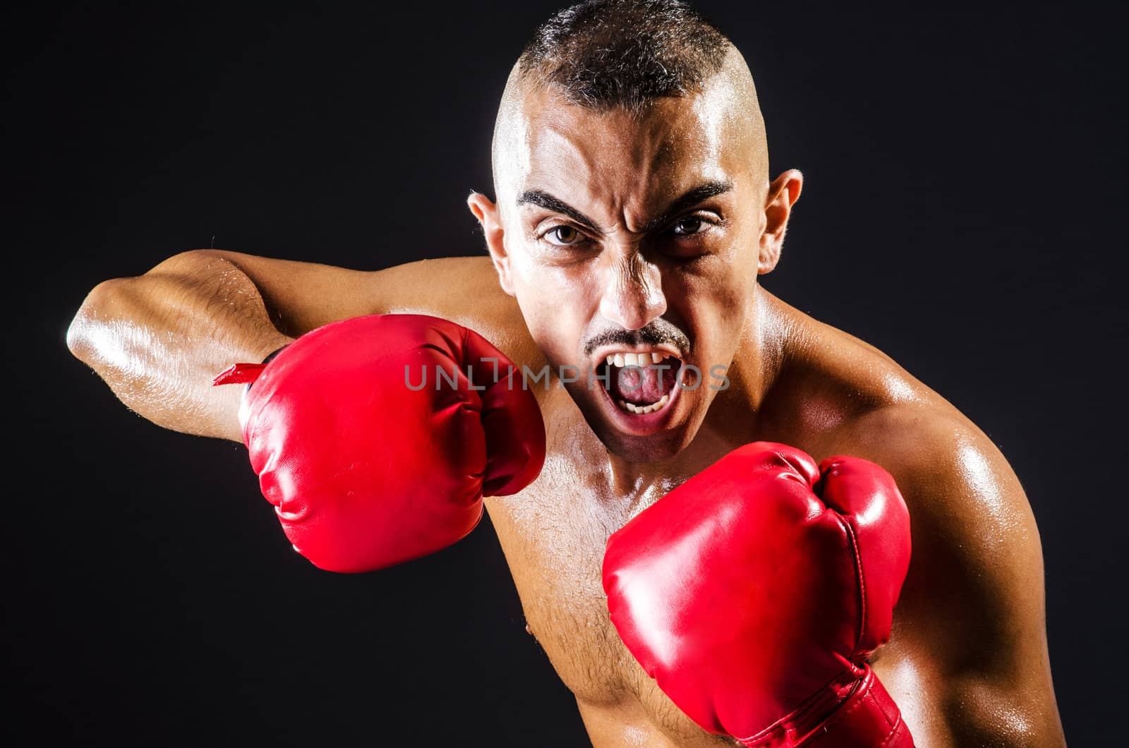 Boxer with red gloves in dark room