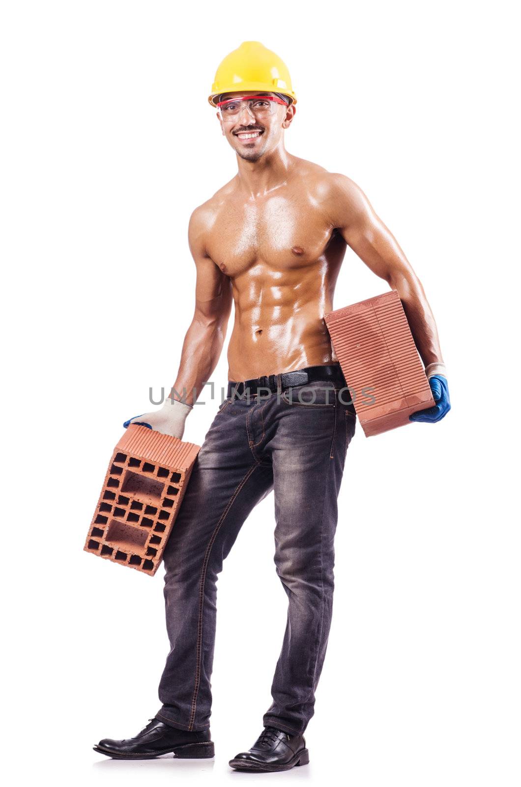 Muscular builder with bricks on white