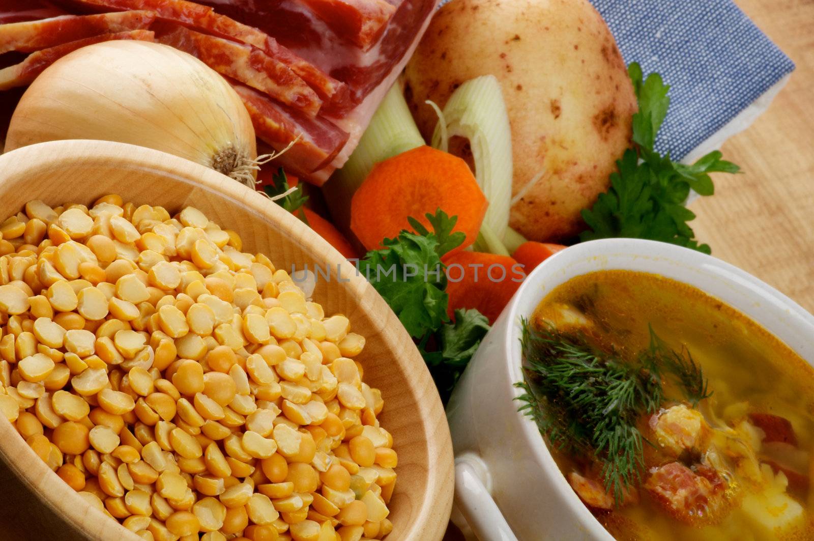 Pea Soup and Ingredients with Yellow Pea, Potato, Carrot, Leek, Onion, Parsley and Smoked Ham closeup