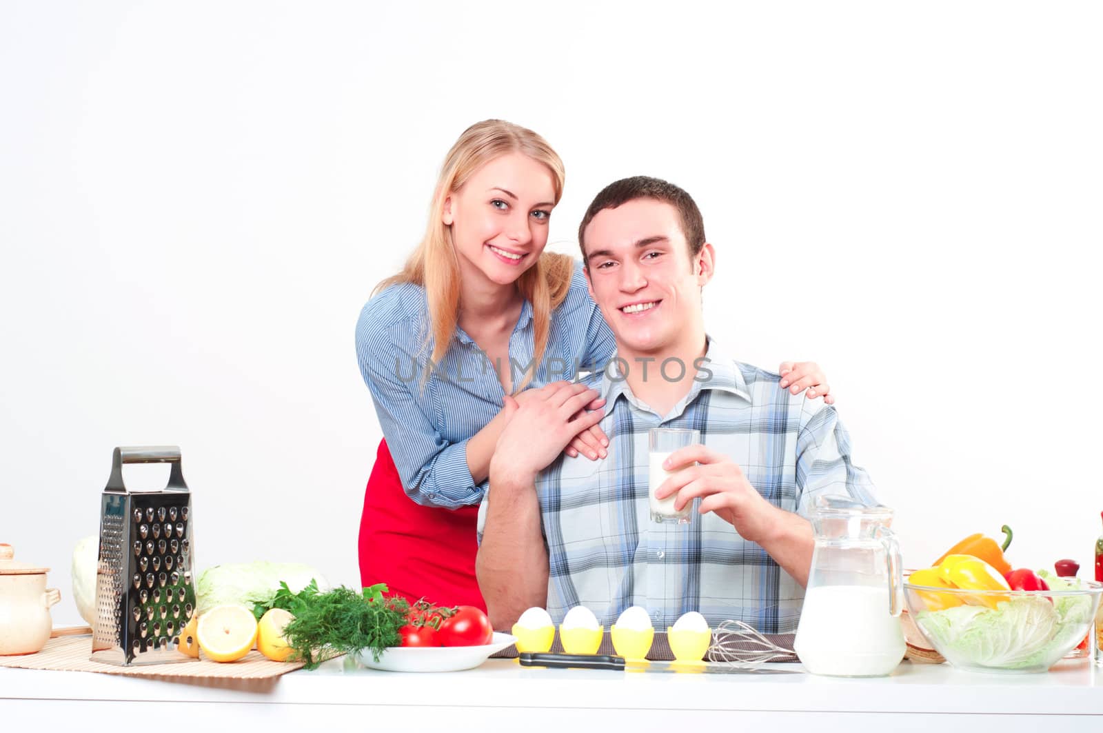 wife embraces the husband, he holds a glass of milk