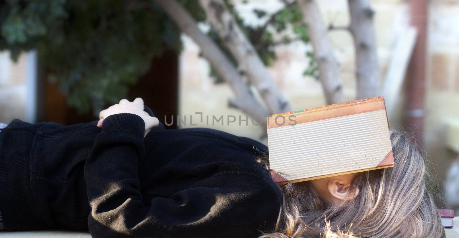 Student sleeping with a book over face by annems