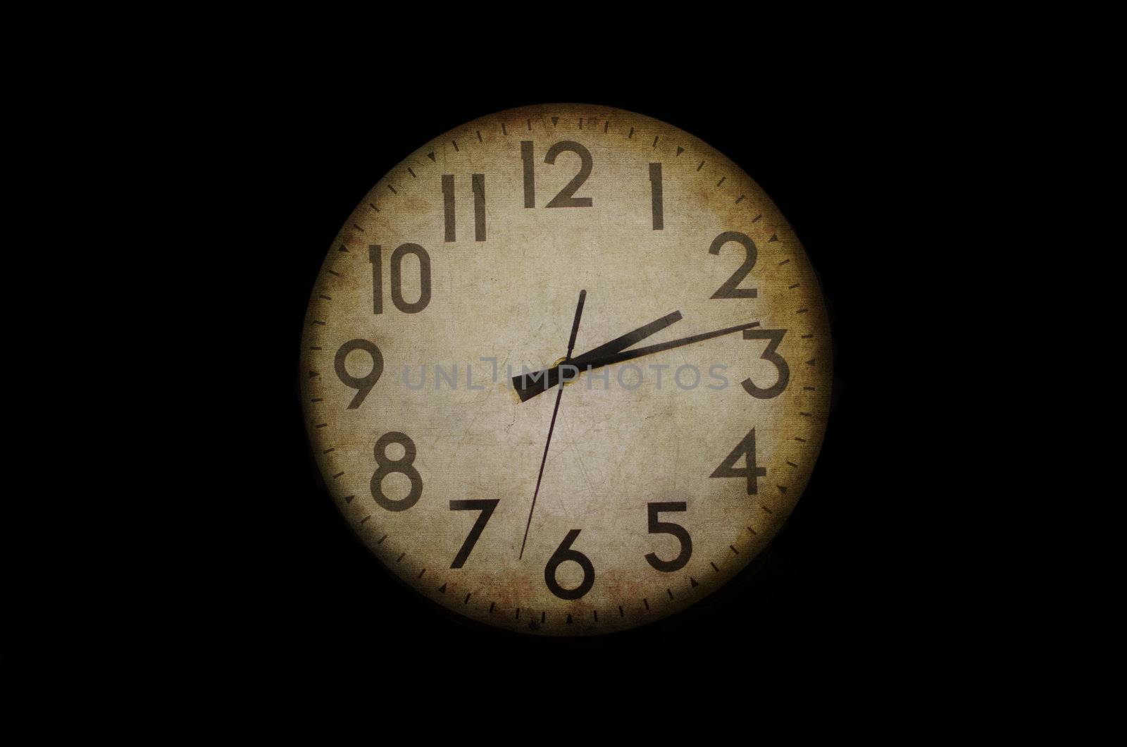 Old looking clock face showing the time. Conceptual image with added effects to appear old, grunge and vintage.