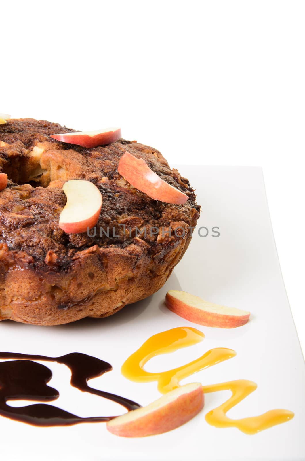 Apple coffee cake on a platter with swirls of chocolate and caramel, isolated on a white background