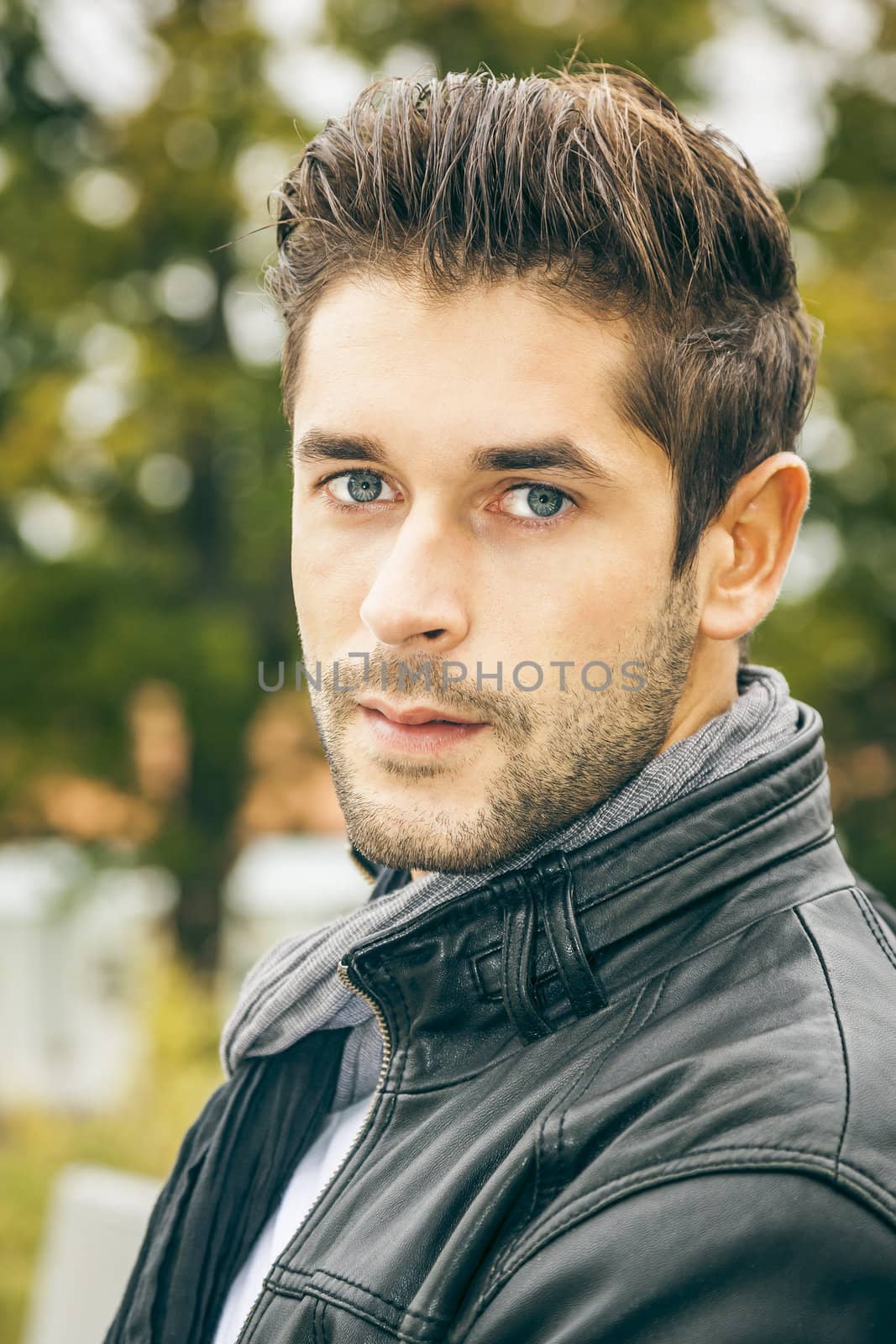 An image of a young man with a black leather jacket