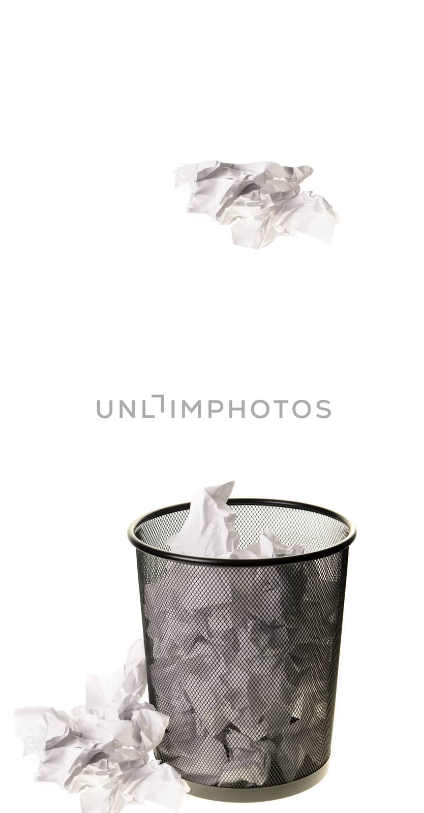 Paper being tossed into a garbage can, isolated on a white background.