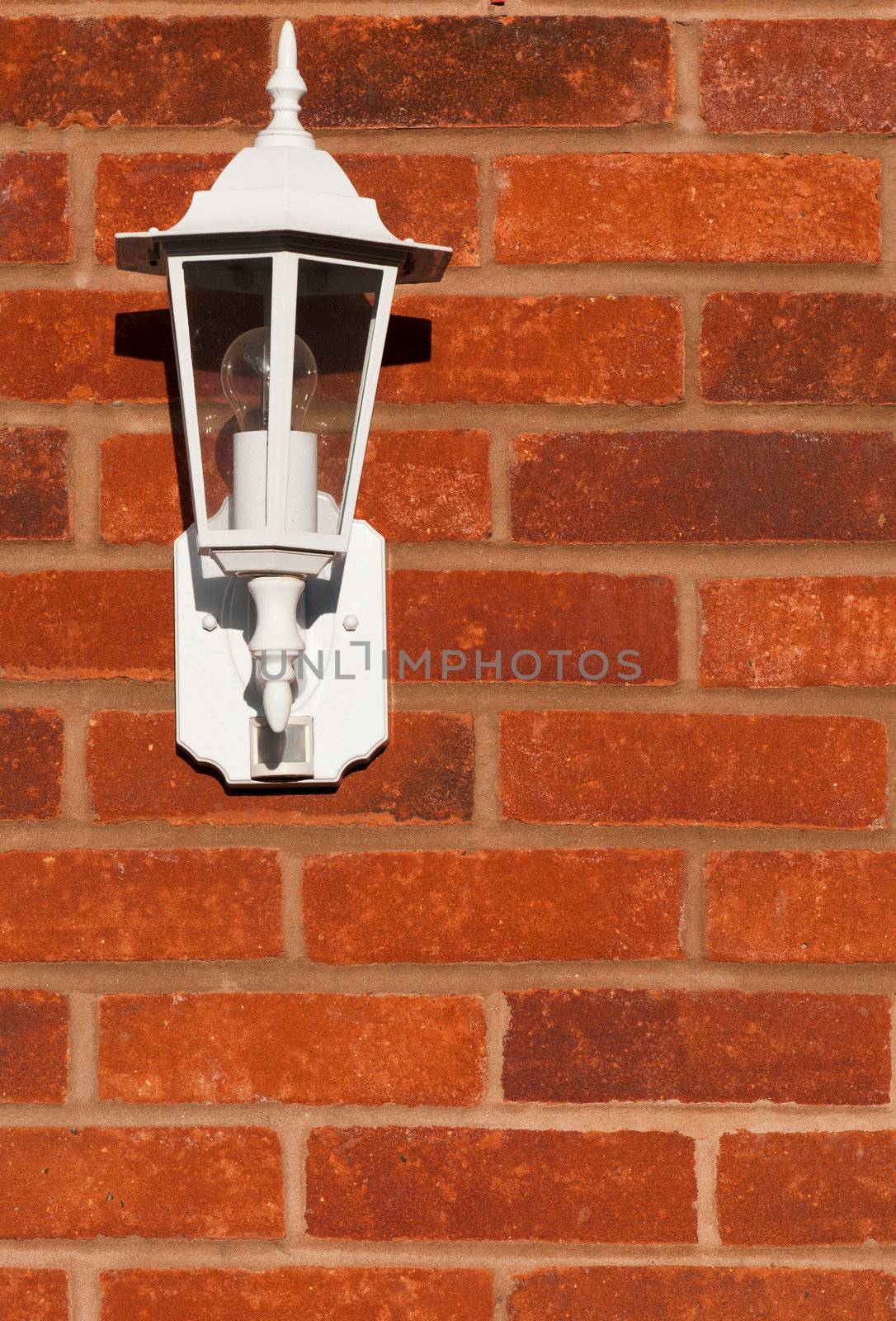 white classic lamp on a brick wall (copy-space available)