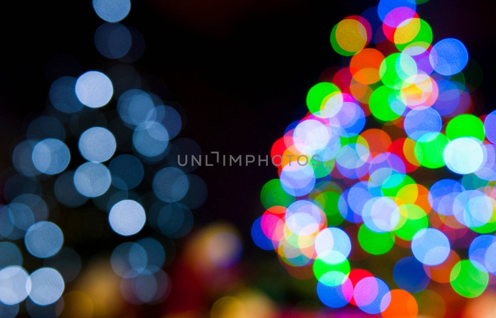 two blurred christmas tree lights on a black background