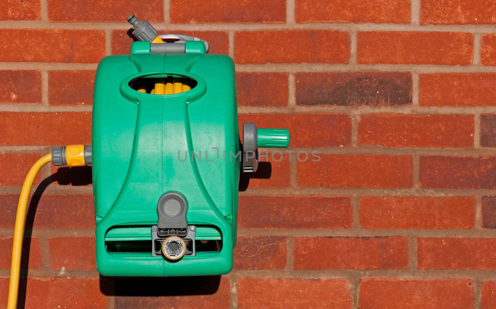 garden hose reel kit installed on a brick wall (copy-space available)
