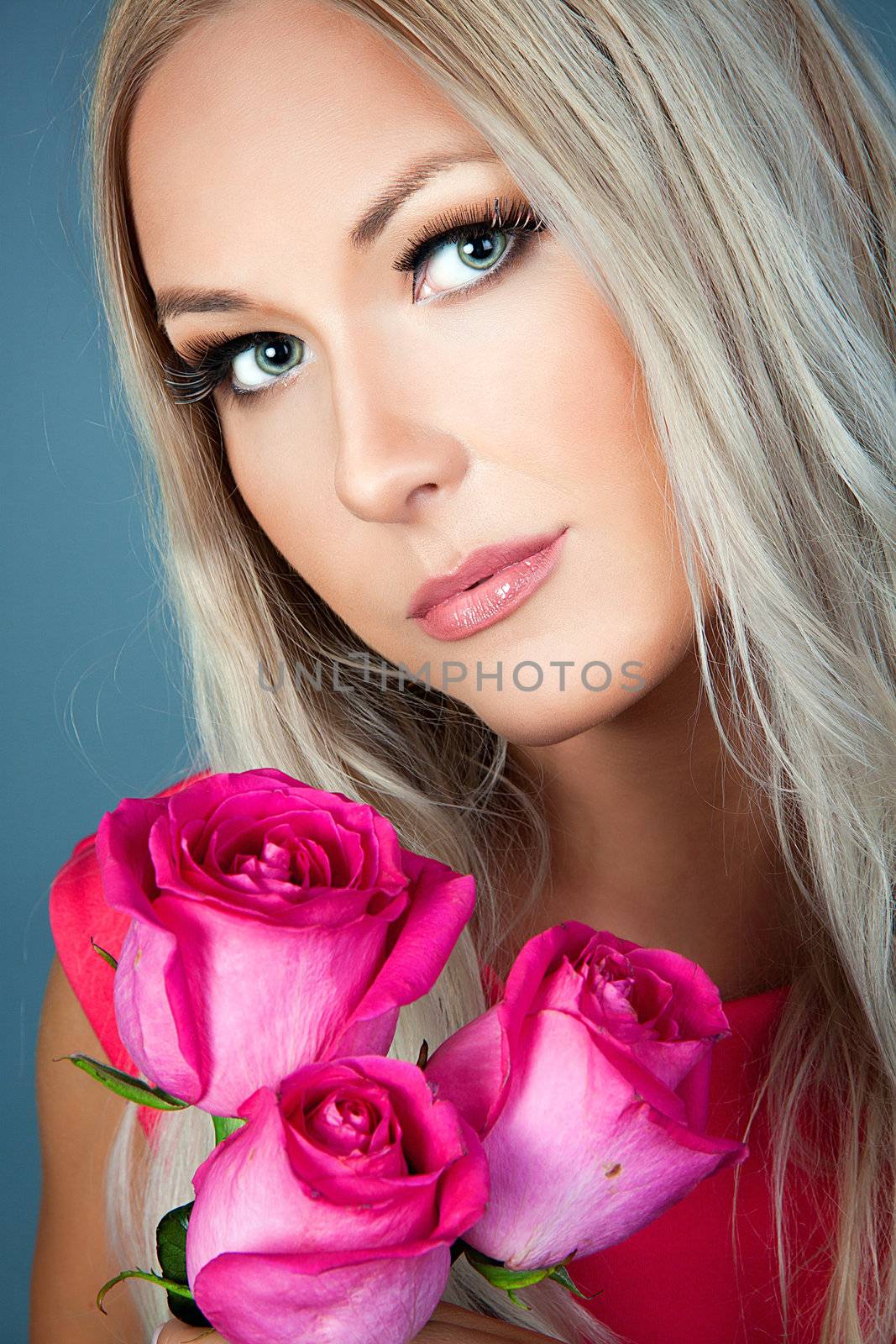 Blond girl holding three pink roses