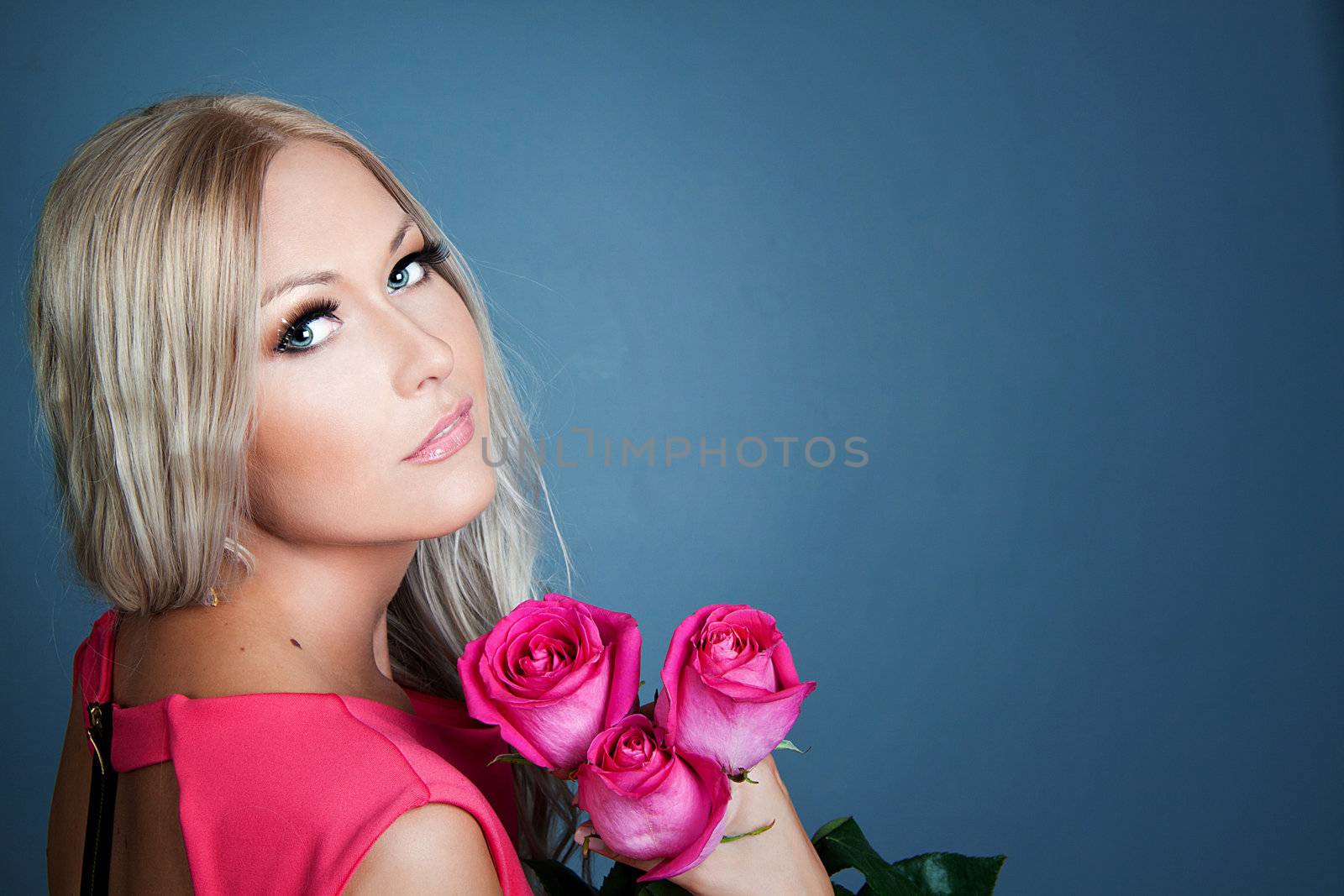 Blond girl holding three pink roses