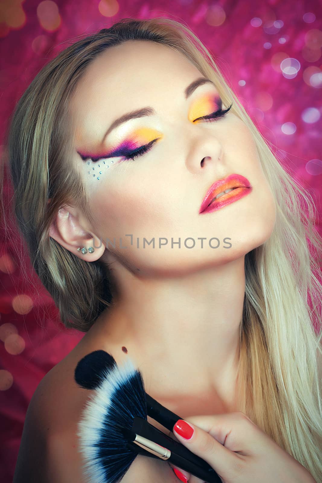 Close up portrait of a blonde girl holding brushes 