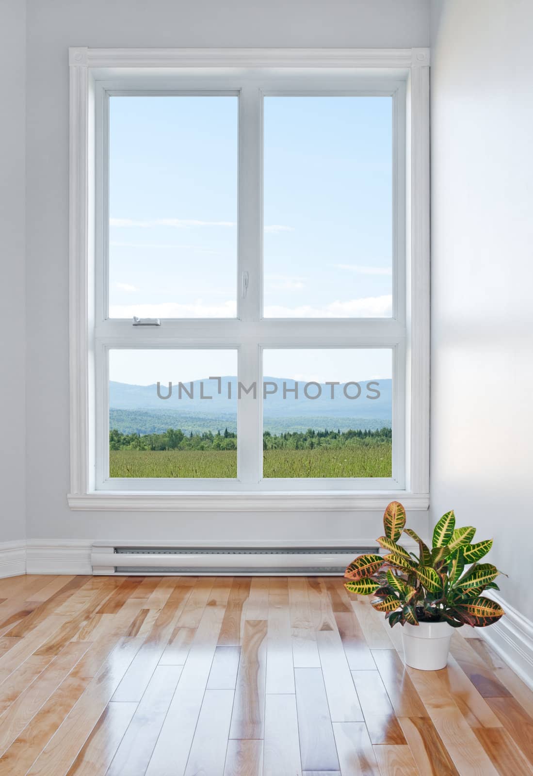 Empty room with beautiful view over field and mountains.