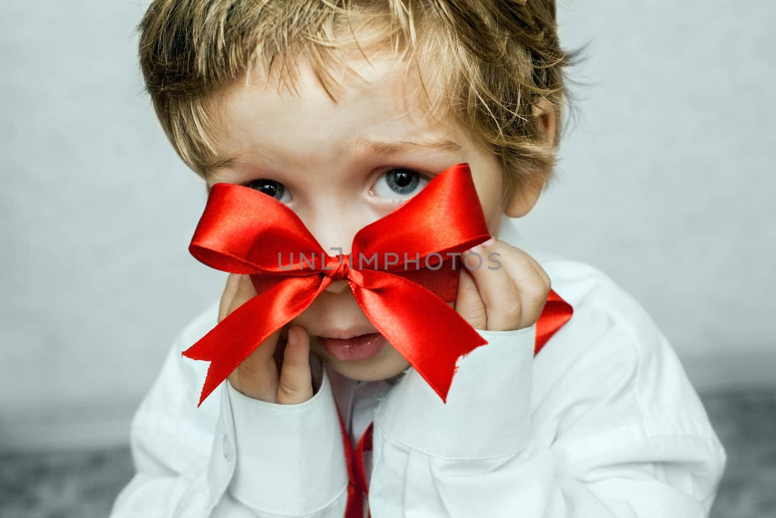 little boy with a red bow in hand