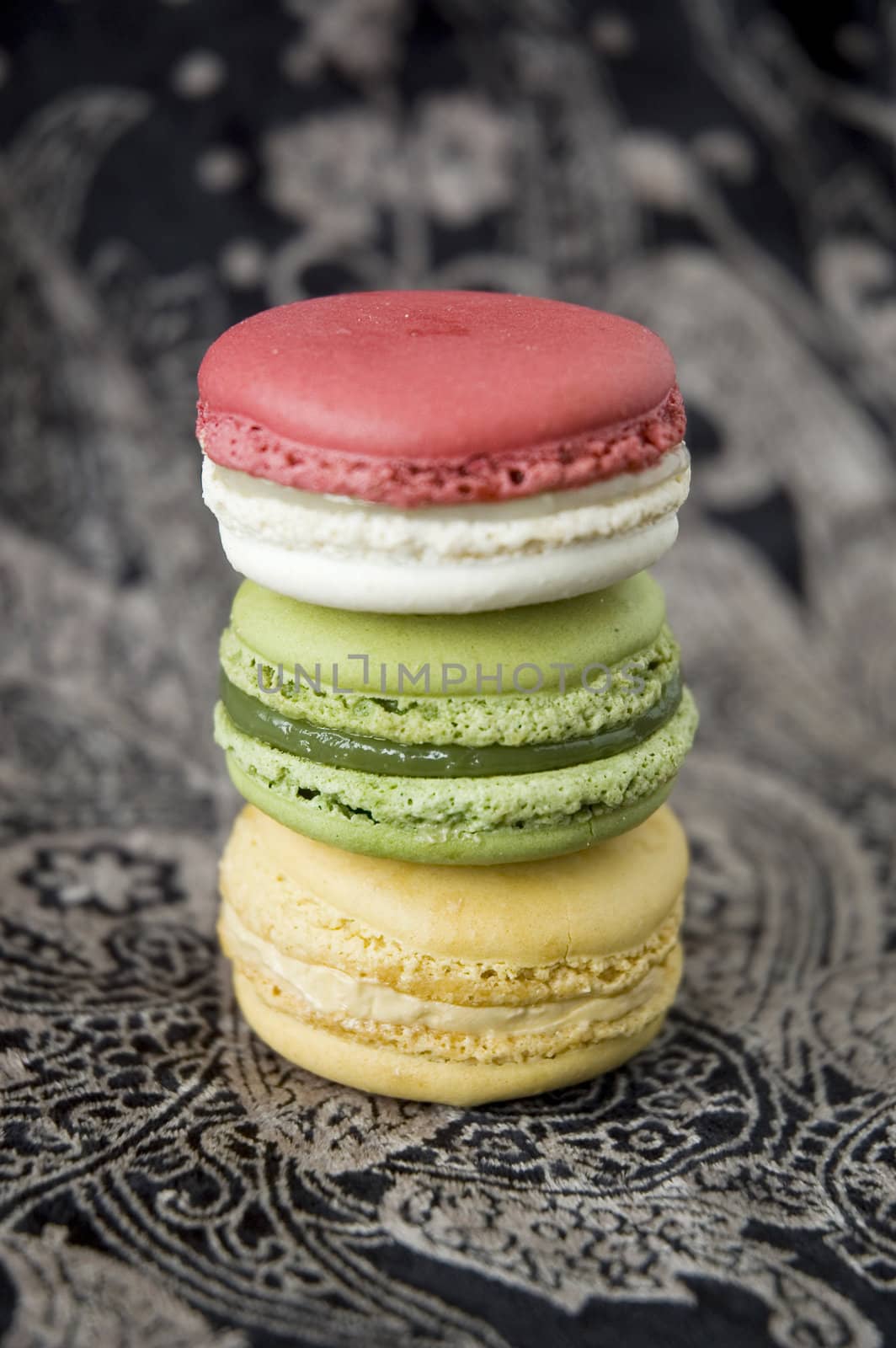 three color macarons on black background