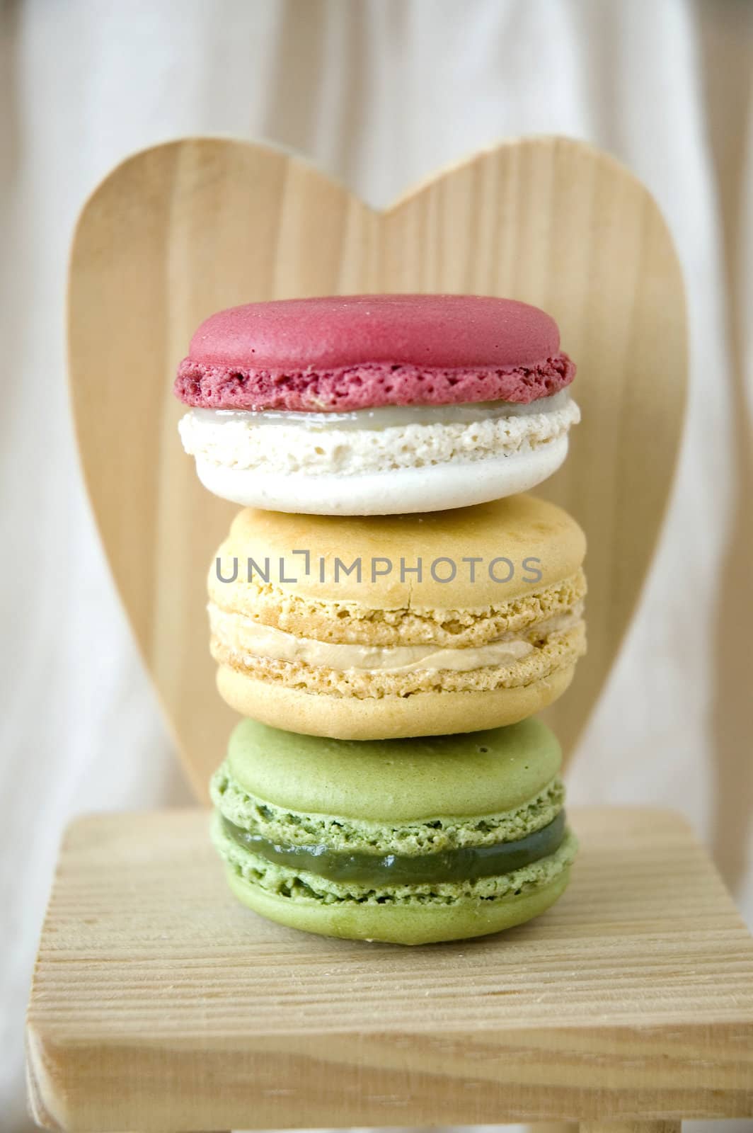 stack of macarons on wooden heart shape background