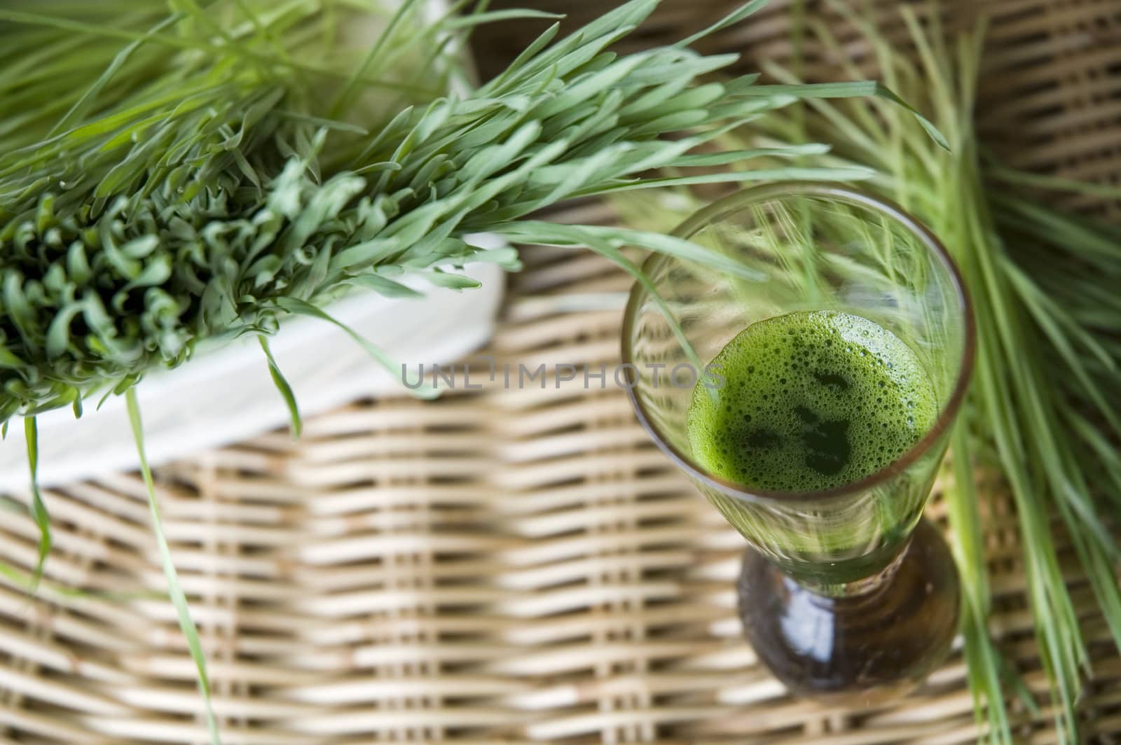 close up top view of wheatgrass drink with wheatgrass background