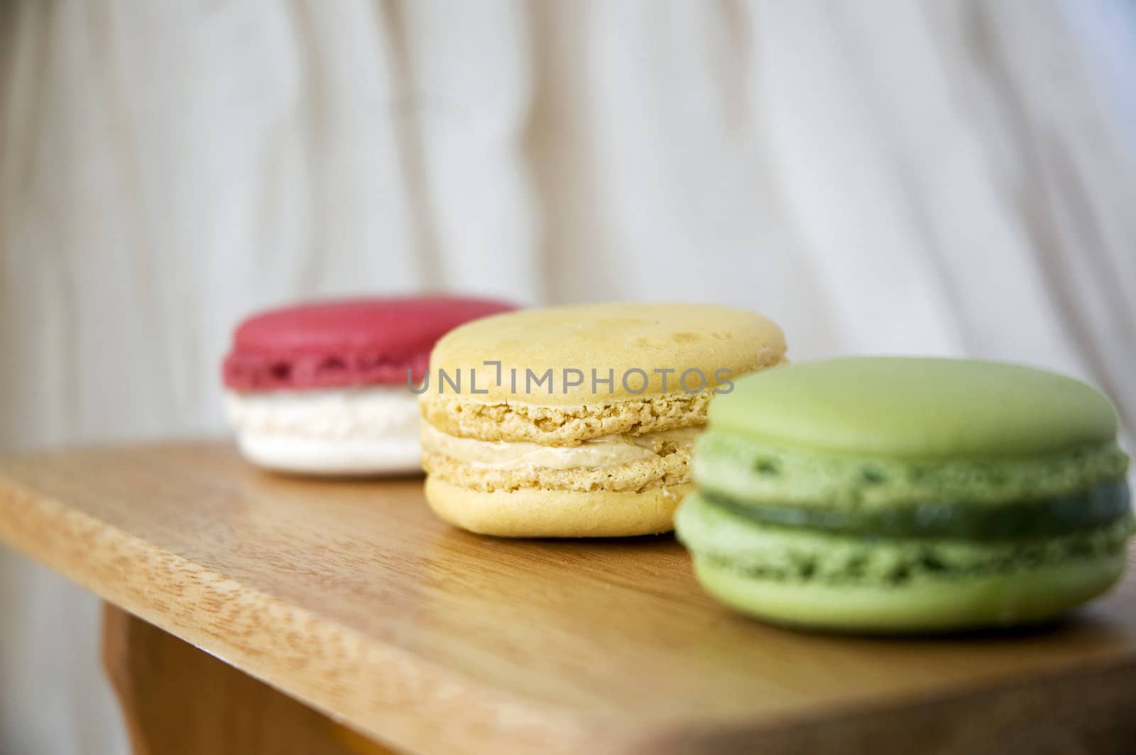 close up vanilla cream macaron in line