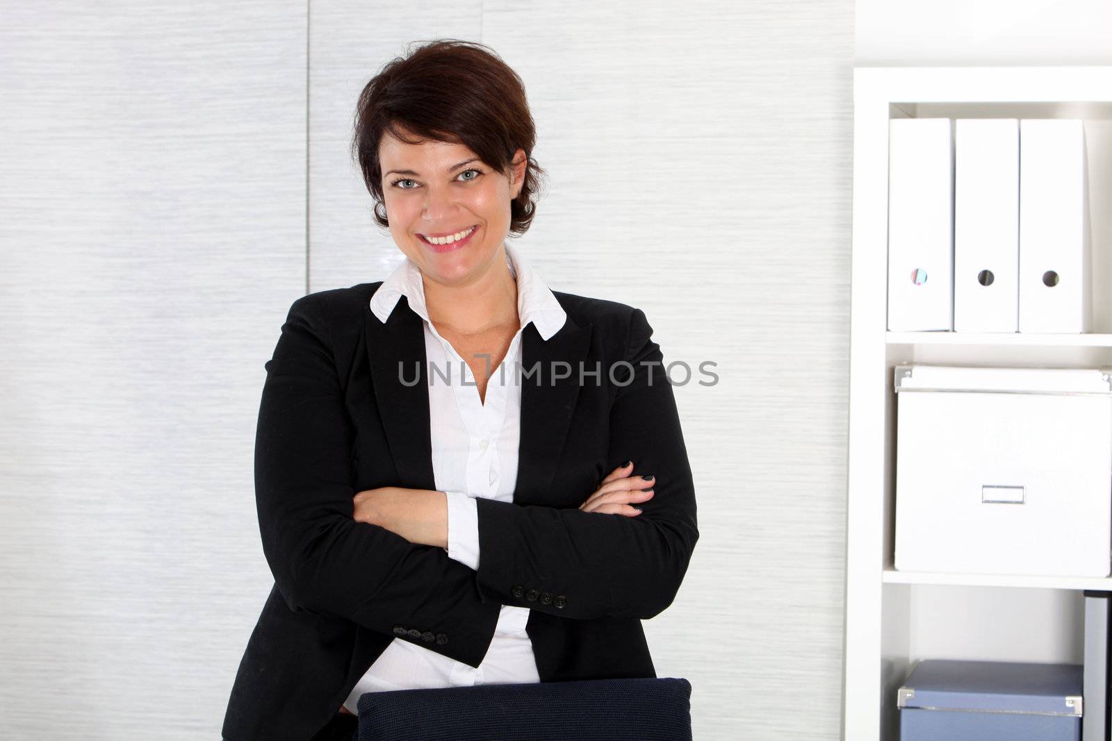 Business woman stands at her desk by Farina6000