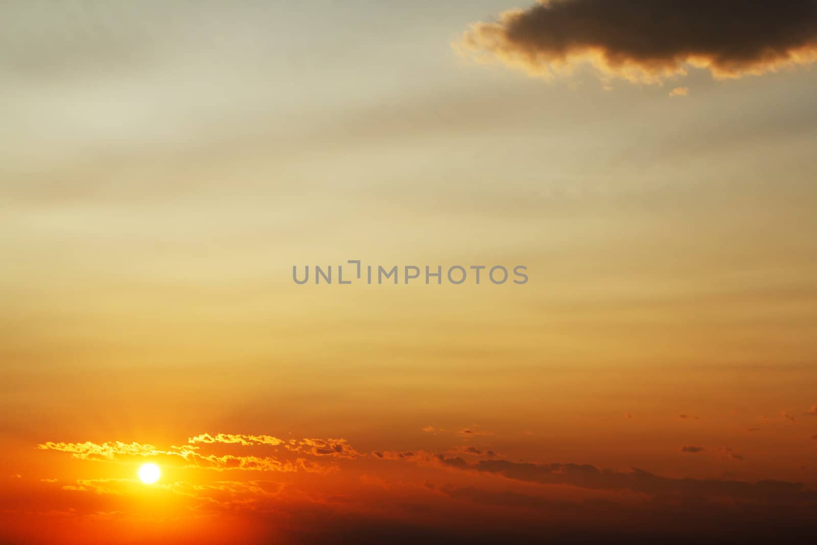 Bright orange sunset sky with cloud and space for text