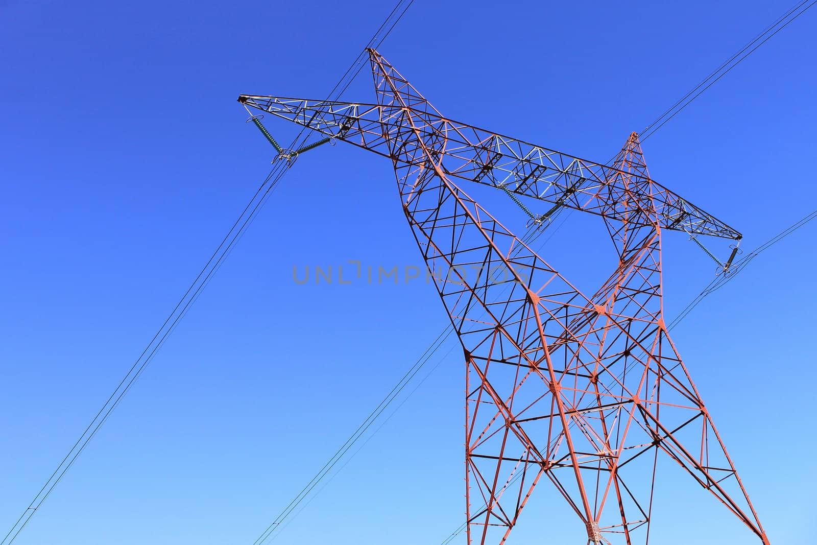 on an electricity pylon against blue sky for a renewable electricity or nuclear