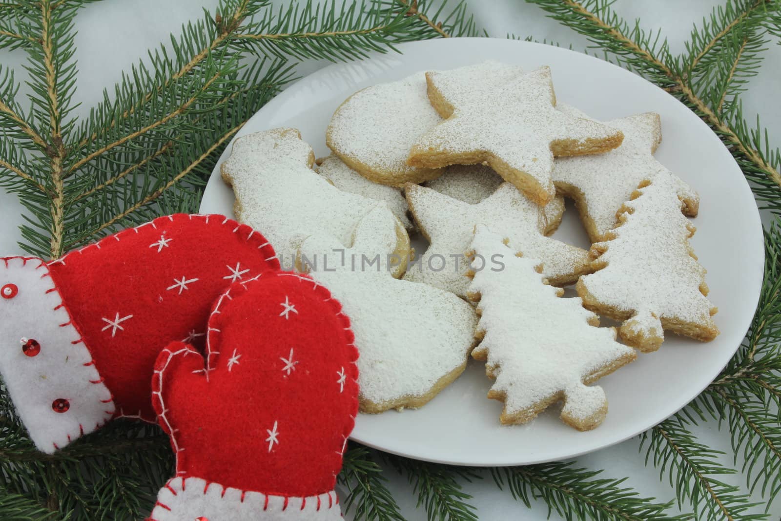 Christmas cookies and sewn holiday mitten decorations, on white background
