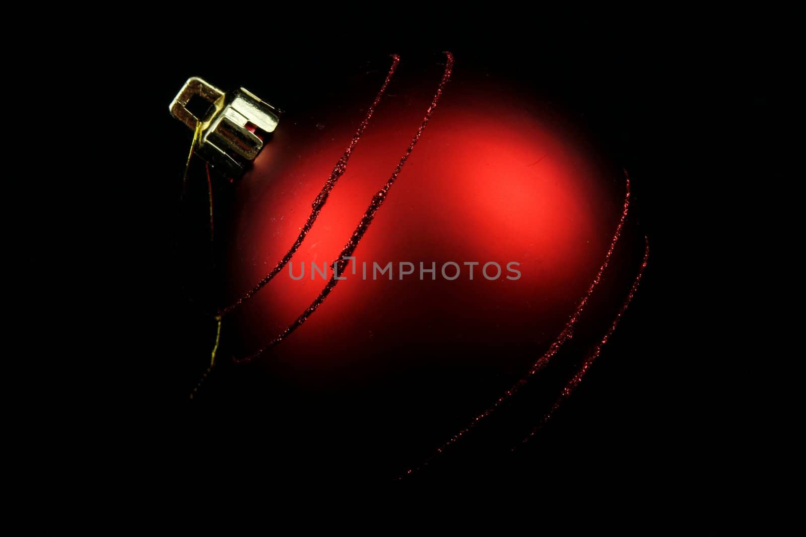 Red Christmas bulb with black background and dim light
