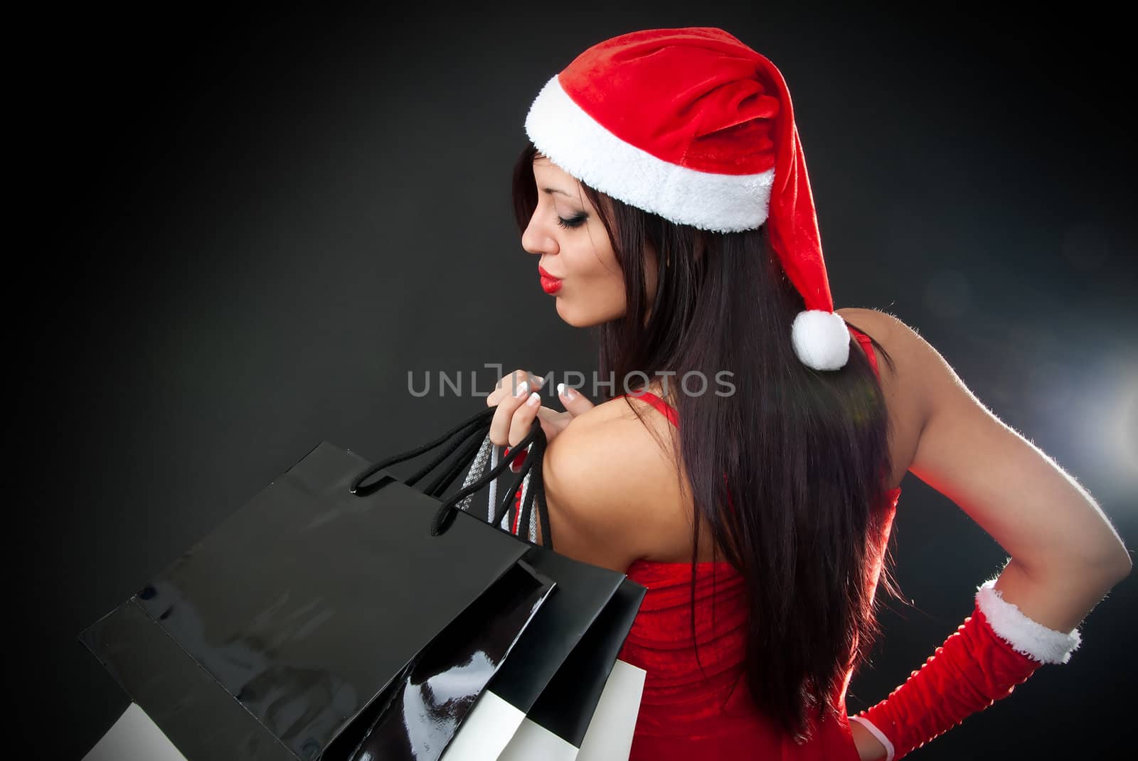 Portrait of Beautiful sexy girl wearing santa claus clothes with shopping bags