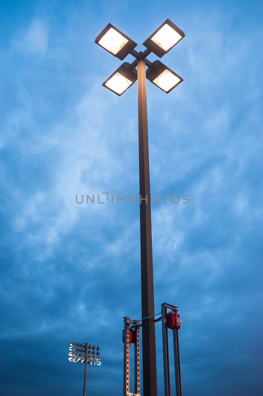 Street light at dusk against blue cloudy sky