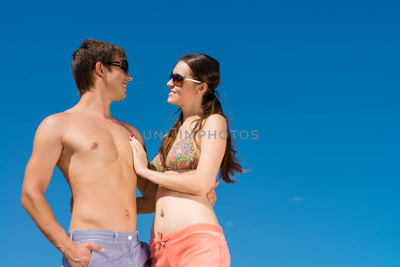 Young couple hugging on a background of blue sky, hold together honeymoon