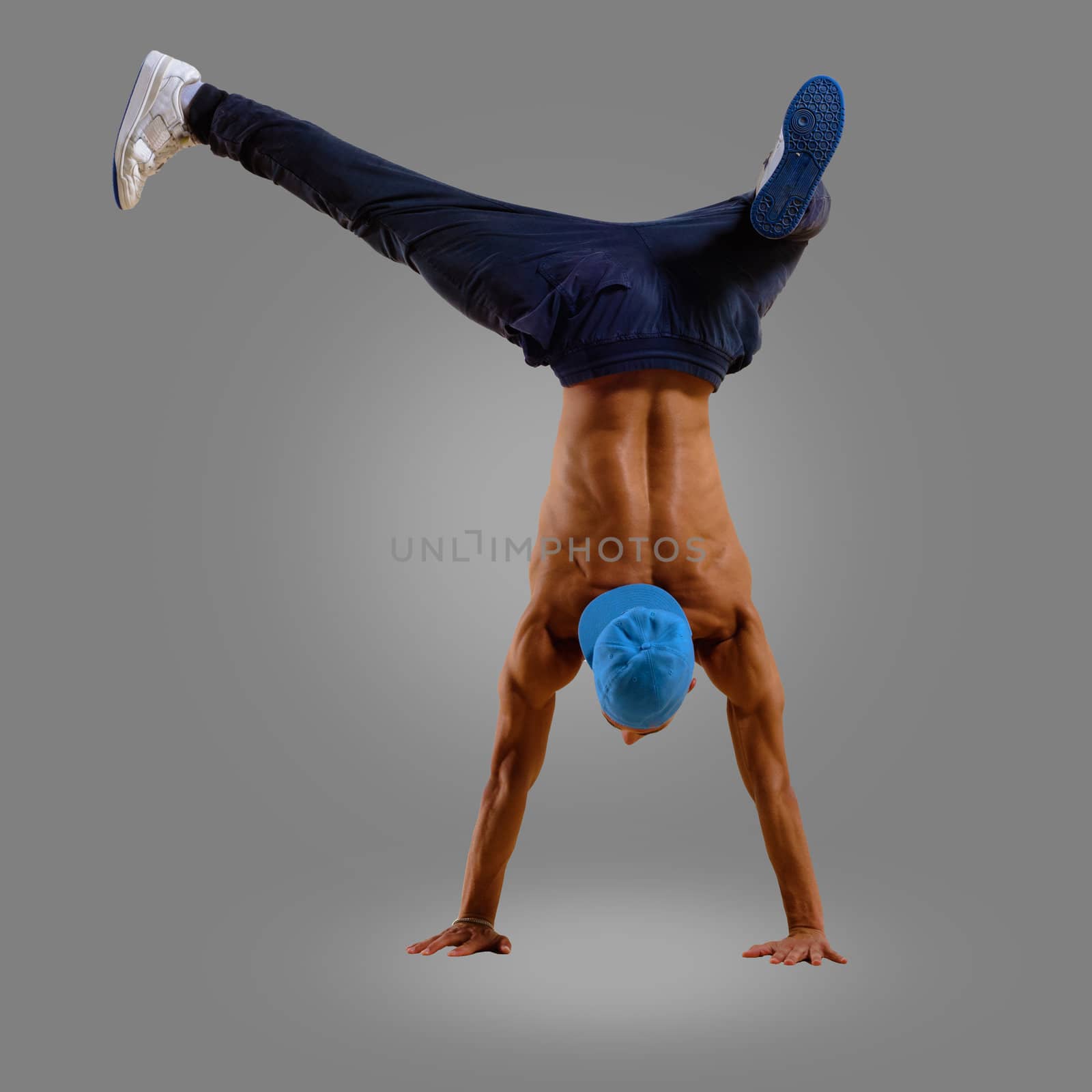dancer stand on the hands on a gray background