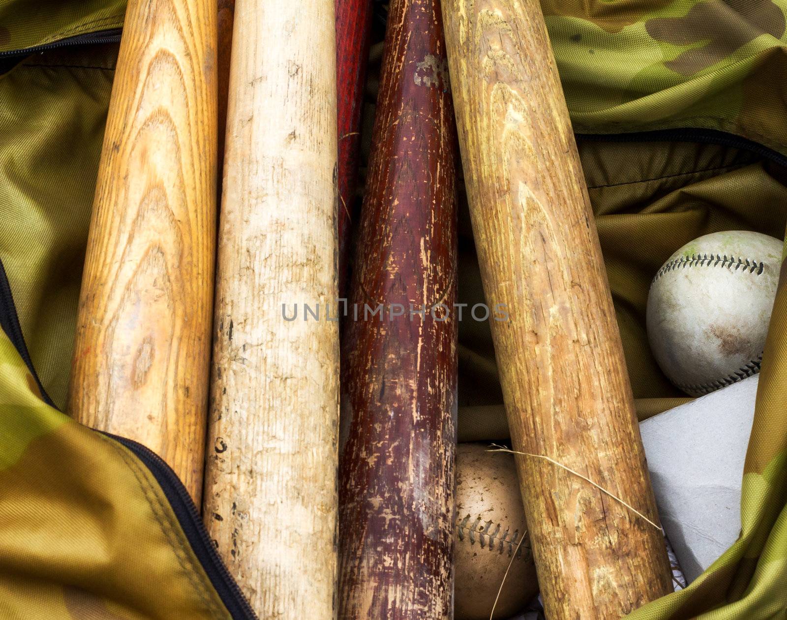 Bats and softballs in a player's equipment bag.