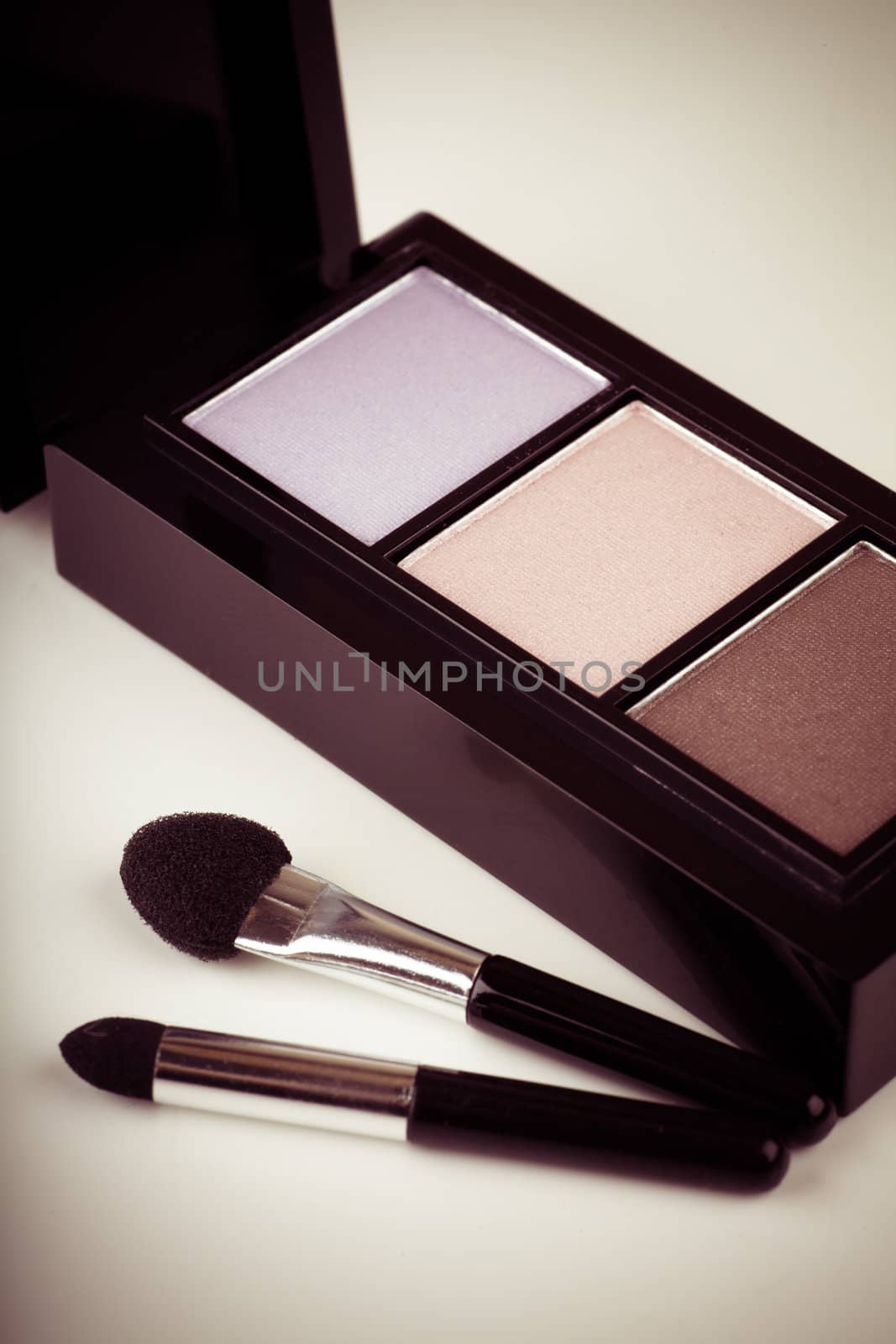 Closeup view of eye shadows with three colors. Toned image