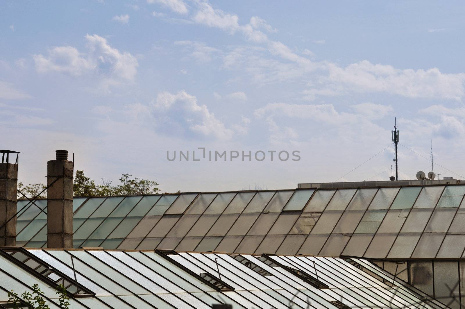 Greenhouse glass roof and cloudy sky. Abstract background.