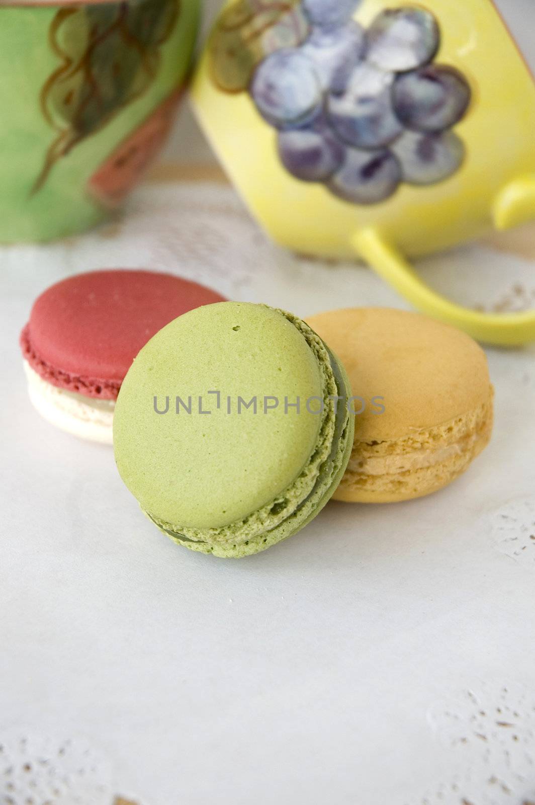 french macarons with colorful cups background