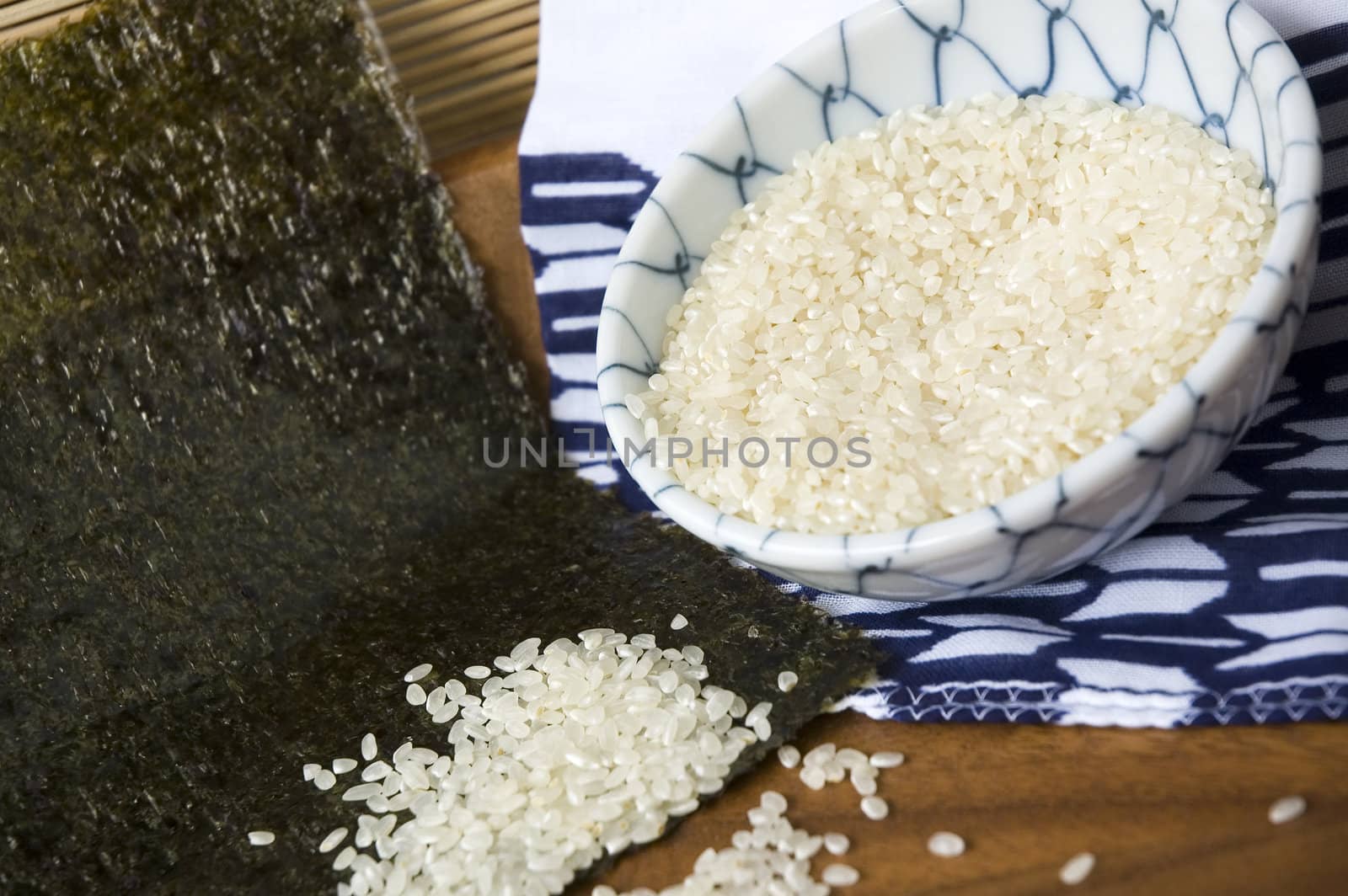 uncooked japanese rice out of bowl on seaweed