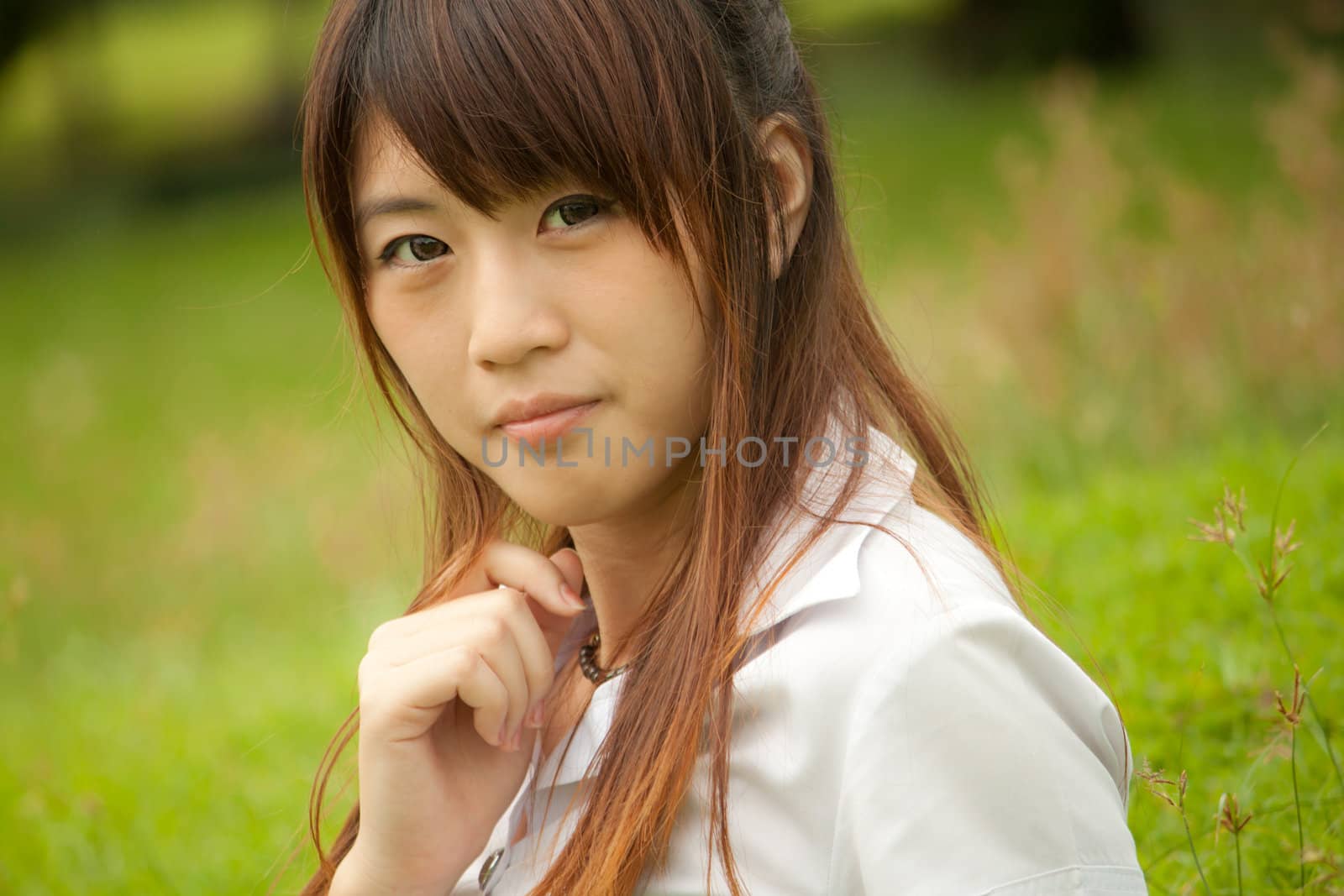 Beautiful young healthy Thai girl portrait in the green park