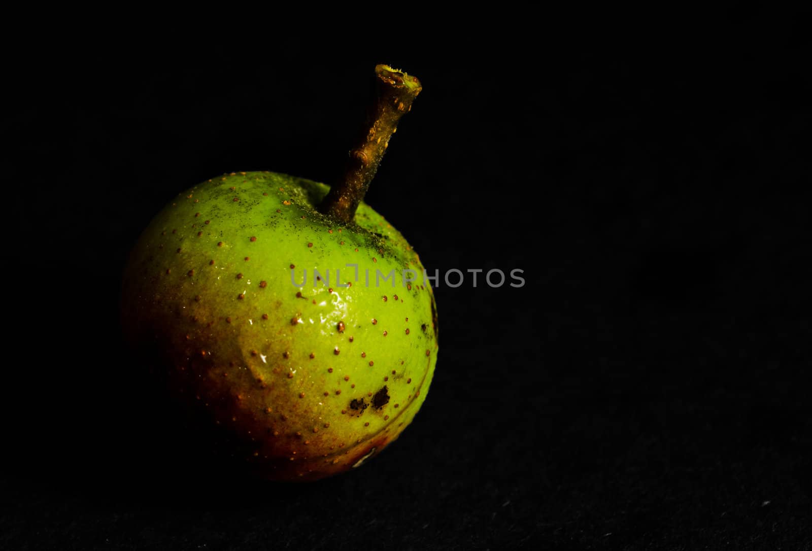 Studio lit crab Apple with a black background.
