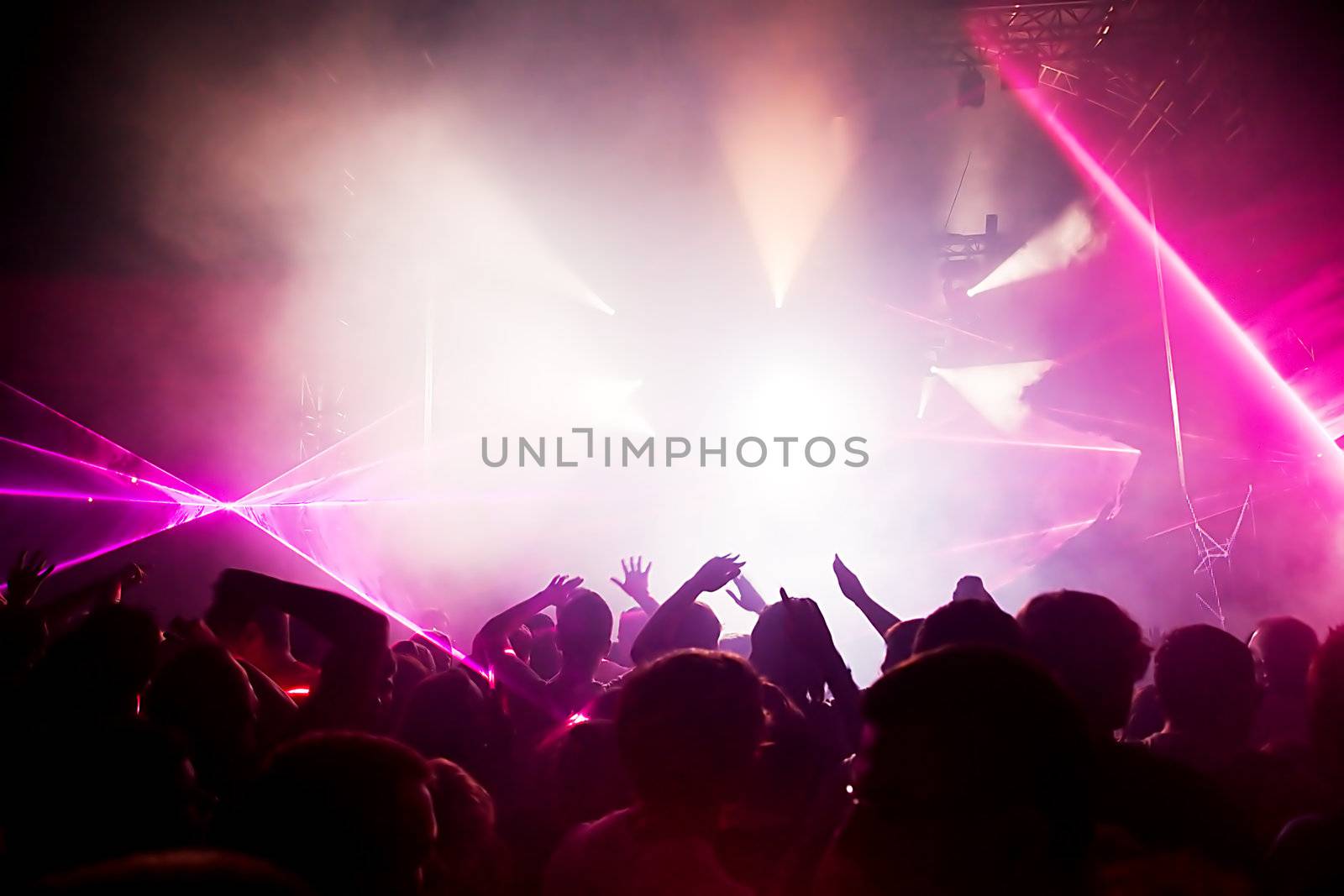 People with hands up having fun on a music concert / disco party. Dynamic motion.