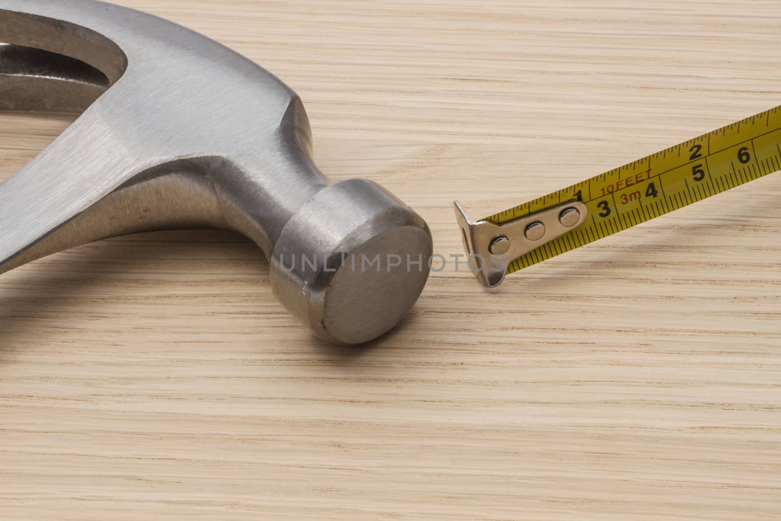 Old hammer and tape measure on wood background 