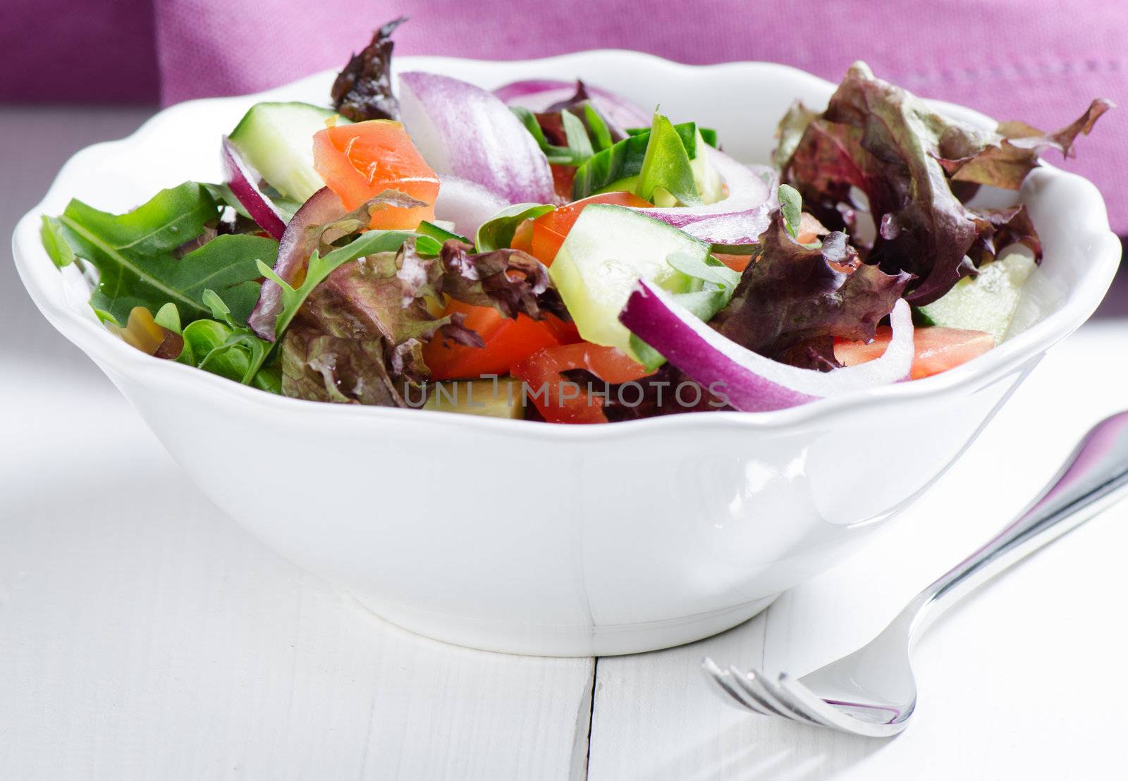 Summer salad on white wooden table