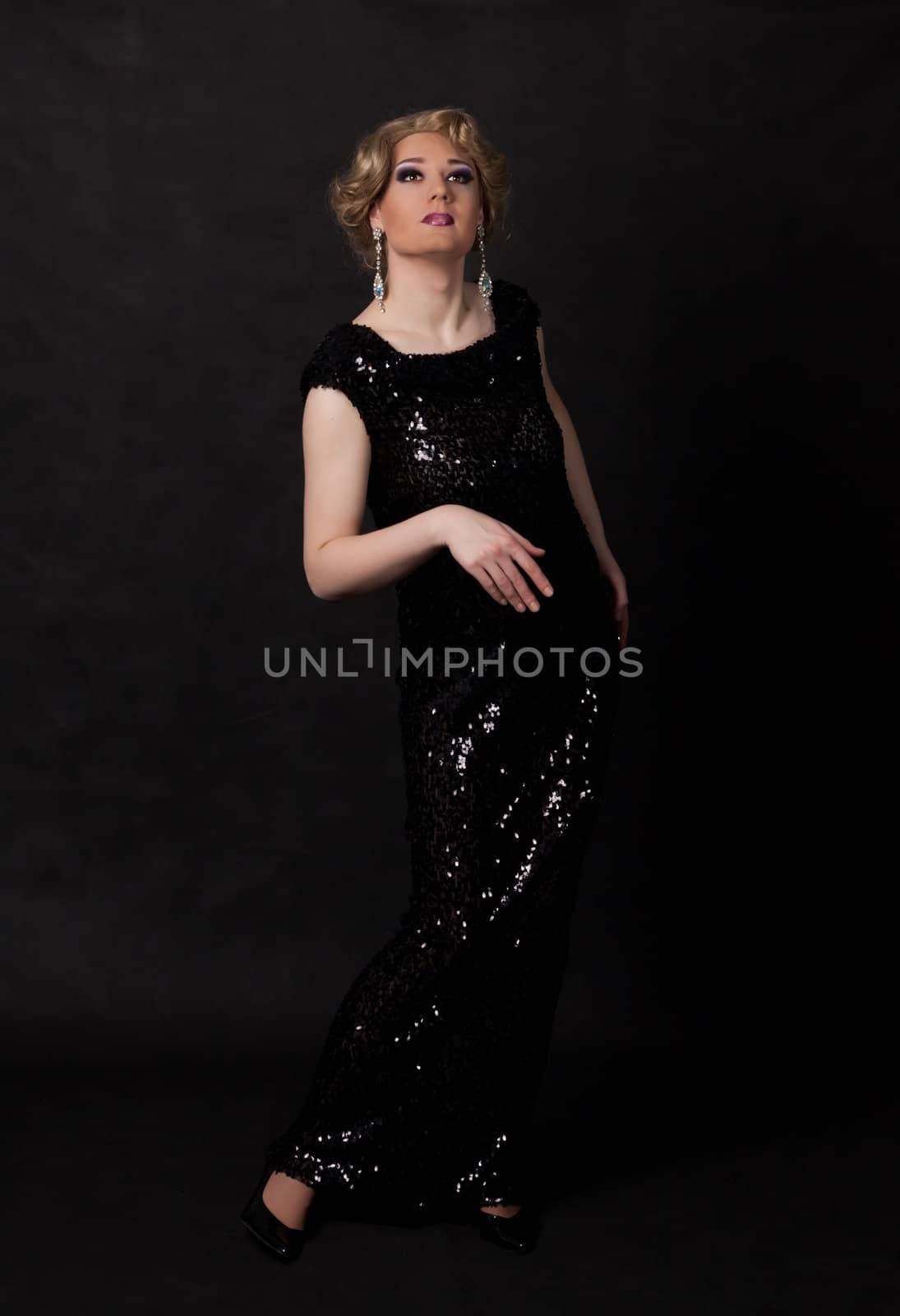 Full length portrait of drag queen. Man dressed as Woman, on black background