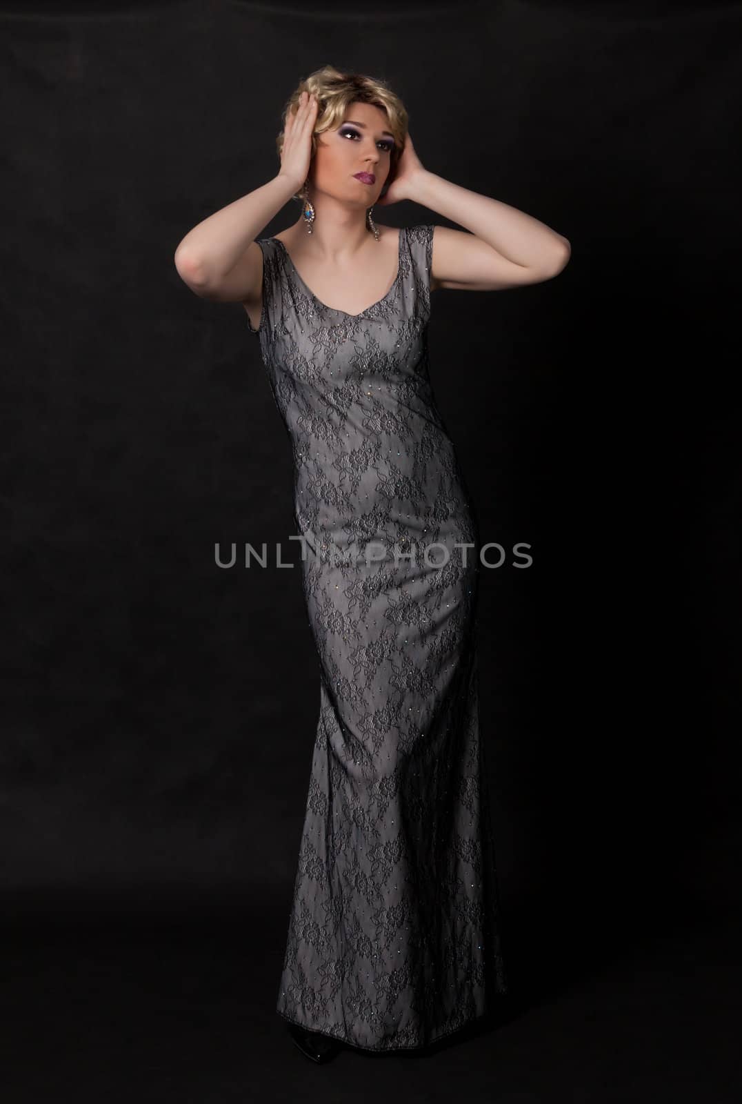 Full length portrait of drag queen. Man dressed as Woman, on black background