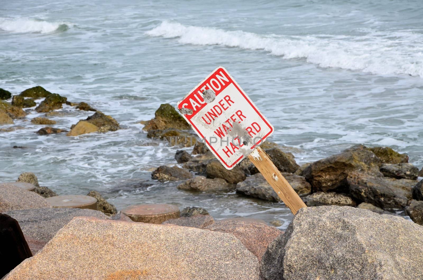 A caution sign along the rocky shore in North Carolina