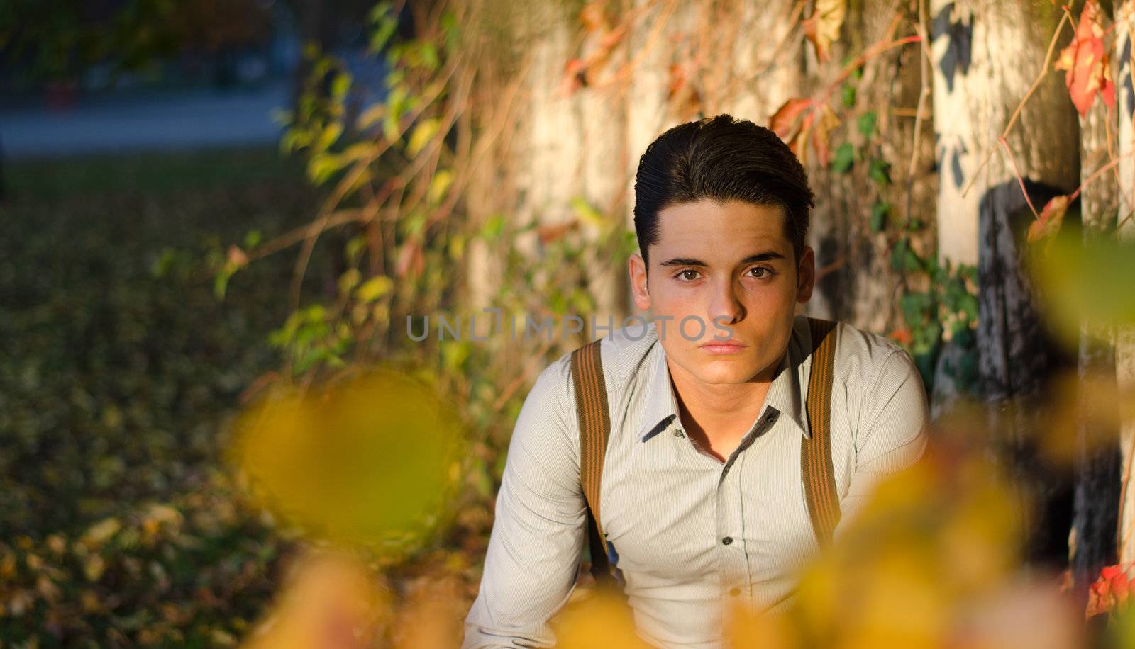 Handsome young man  in fall (autumn) near wooden fence by artofphoto