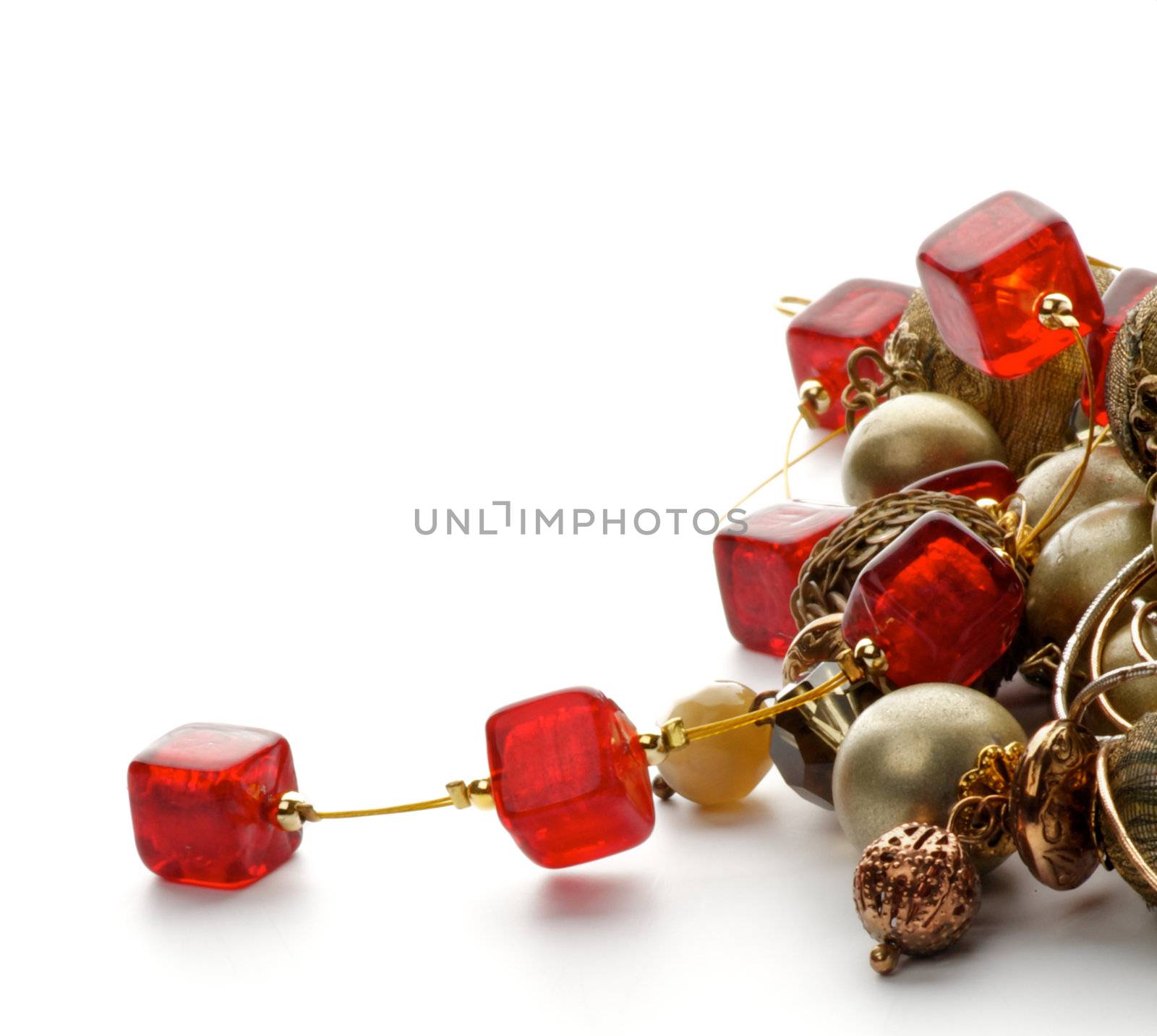 Heap of Jewelry with Gold Bracelets and Ruby Necklace closeup on white background
