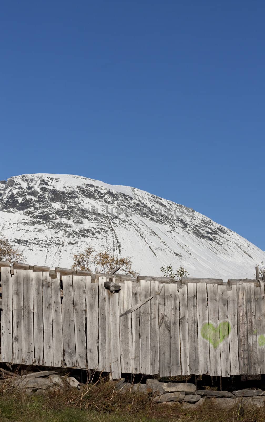 Old wooden board in front of a winter mountain