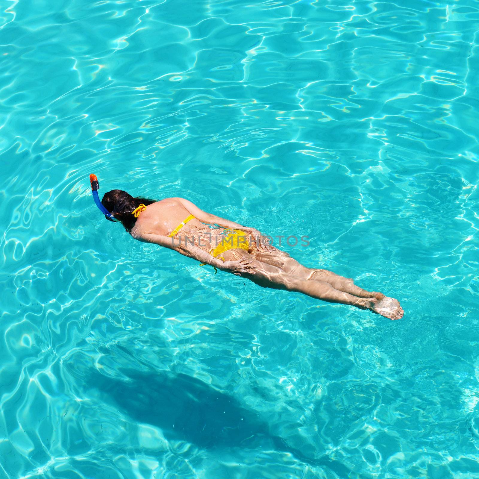 Woman snorkeling in crystal clear turquoise water at tropical beach