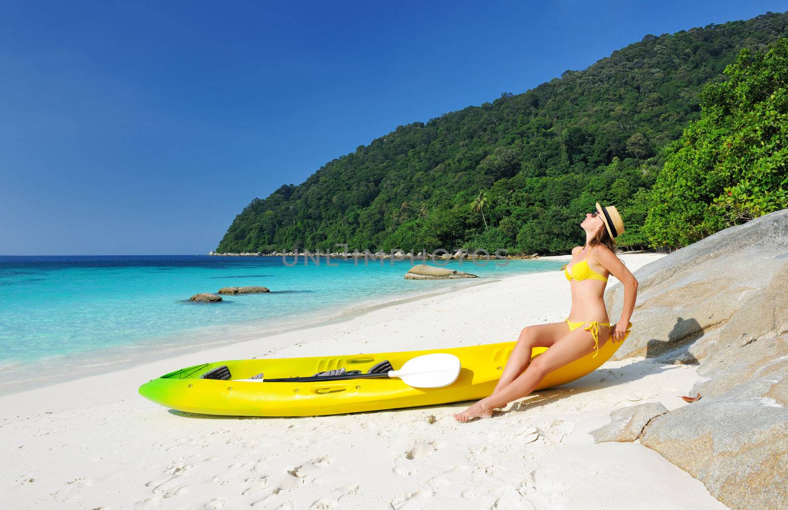 Woman in sunglasses at beach wearing hat and kayak