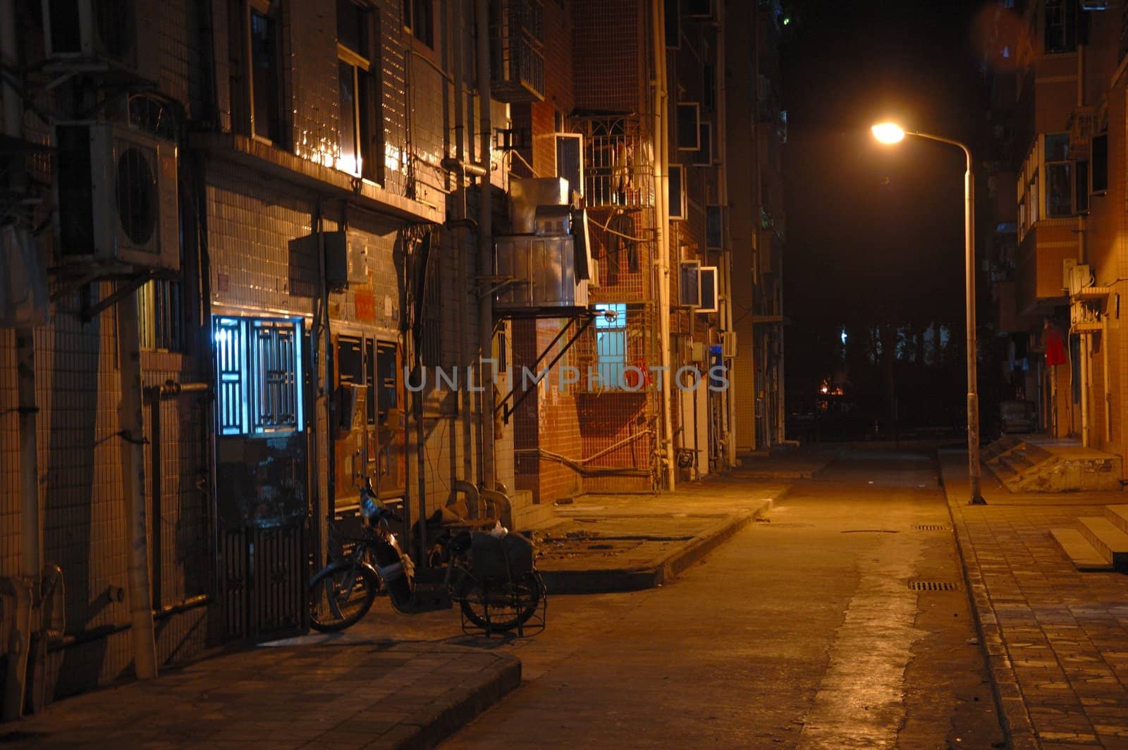 Empty street and tenement house by night in Chinese city. 